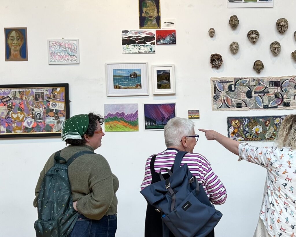 Two participants looking at artworks on display at the Caring Spaces exhibition